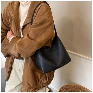 Detailansicht der schwarzen Lederstruktur mit Kieselmaserung an einer minimalistischen Tasche