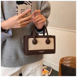Detail of retro contrast handbag featuring unique spherical handle connectors and PU leather