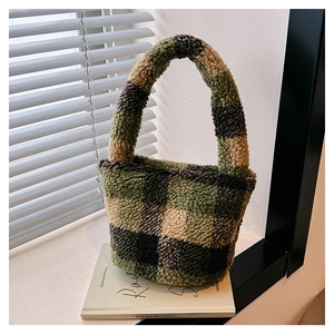 Close-up of green checkered plush handbag texture on a windowsill with soft light
