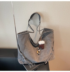 Détail du grand sac cabas gris en similicuir suédé avec breloque et boucle latérale