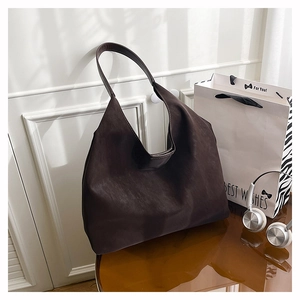 Detail of minimalist dark brown tote bag showing soft matte leather texture and wide strap