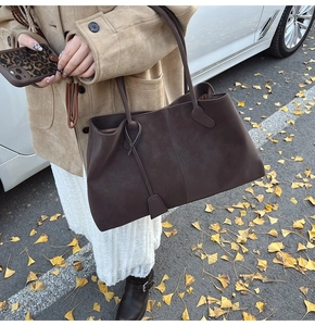 Brown suede tote bag side view on ginkgo leaves background with luxury minimalist style