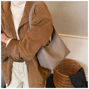 Nahaufnahme der grauen Leder-Tote-Bag mit Litschi-Muster für stilvolle Pendlerlooks