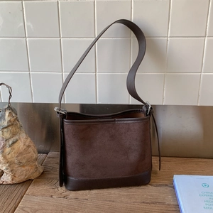 Detailed view of deep brown vintage patchwork shoulder bag with suede and leather textures