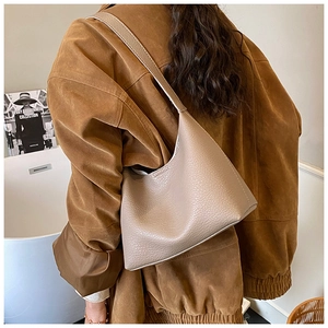 Detailansicht der taupefarbenen Umhängetasche mit Lychee-Muster Leder am Modell