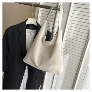 Minimalist cream tote bag styled with a professional black blazer and white shirt