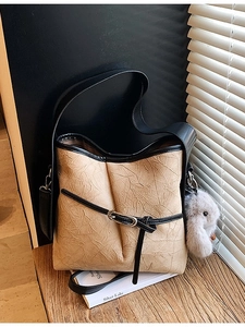 Khaki pleated leather bucket bag with plush rabbit charm and black contrast straps