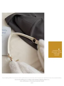 Detail of comfortable leather shoulder strap and golden metal ring on white plush tote bag