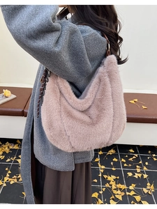 Detail view of pink faux fur tote bag with brown shoulder strap on autumn background