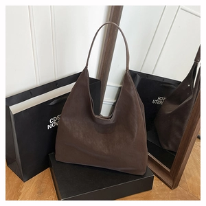 Close-up of vintage brown leather tote bag with soft matte finish in a shopping setting
