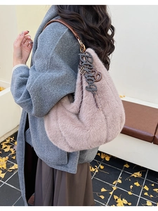 Detail of plush hobo bag in dusty rose with faux fur texture and leather strap