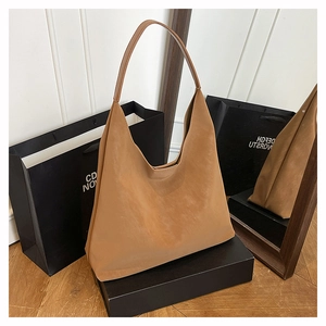 Detailed macro view of the brown suede Hobo bag texture with minimalist shoulder strap