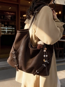 Sac cabas en cuir marron avec surpiqûres contrastées porté par un mannequin femme