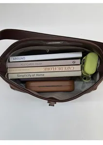 Macro view of dark brown faux leather bag showing spacious interior with two compartments
