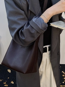 Dunkelbraune Beuteltasche aus Leder mit Kieselmaserung als minimalistische Schultertasche