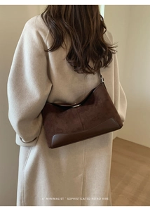 Detail of dark brown suede and leather shoulder bag with minimalist retro stitching