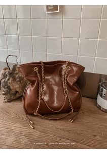 Minimalist retro tote bag featuring golden chain leather straps and a magnetic closure