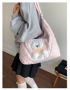 Détail du sac fourre-tout rose matelassé avec un écusson brodé d'un mignon ours blanc