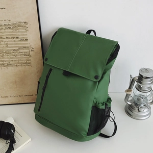 Détail du sac à dos extérieur vert foncé avec rabat et poche latérale en filet pour gourde