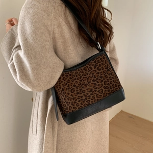 Detail of leopard print patchwork shoulder bag worn with a wool coat for autumn style