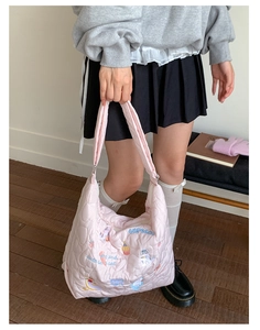 Détail du sac bandoulière rose matelassé avec broderies de cupcakes et chats