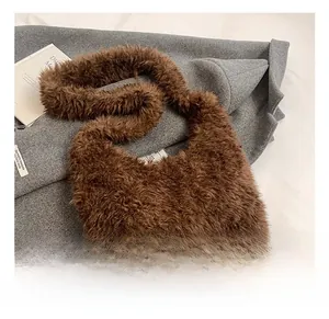 Dettaglio della texture in peluche marrone e dell'ampia tracolla della borsa tote