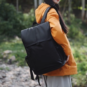 Sac à dos noir léger de randonnée porté par un mannequin en veste orange vive