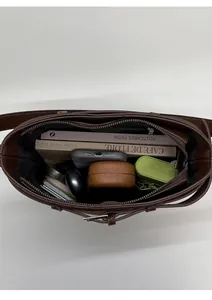 Vue de dessus montrant l'intérieur spacieux et la poche zippée du sac seau en cuir marron