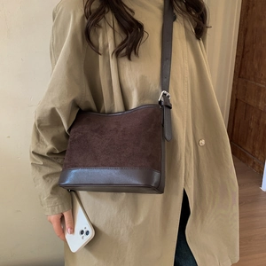 Detail of dark brown tote featuring a mix of smooth leather and matte suede textures
