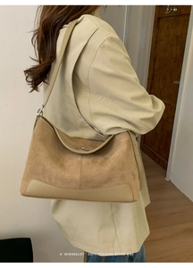 Detail of adjustable strap and silver lock on a khaki matte leather shoulder bag