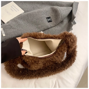 Detail of dark brown plush handbag featuring smooth lining and secure zipper closure