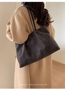 Close-up of minimalist charcoal gray matte suede tote bag with slim shoulder straps