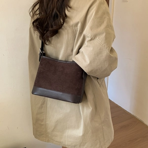 Detail of dark brown patchwork shoulder bag with matte finish and smooth leather trim