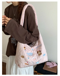 Détail du sac fourre-tout en nylon rose matelassé avec broderie de chiot mignon