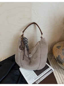 Detail of plush hobo bag with thick faux fur texture and brown leather strap handles
