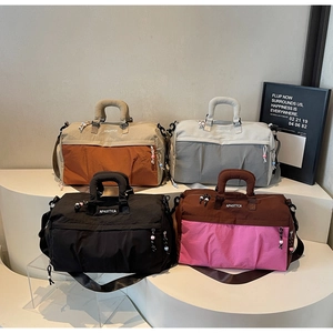 Collection de quatre grands sacs de sport en nylon présentés sur un support blanc moderne