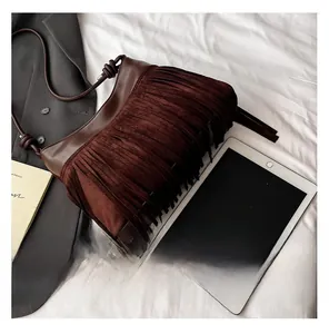 Dettaglio borsa a tracolla marrone scuro con frange e trama scamosciata stile minimal
