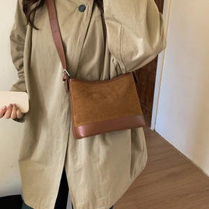 Detail of retro patchwork shoulder bag in brown suede and leather with silver buckle