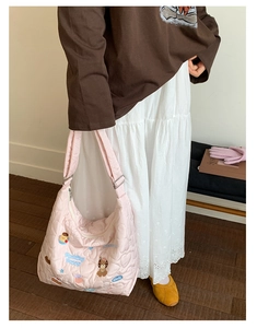 Détail du sac à bandoulière rose avec matelassage en cœur et broderie de chiot