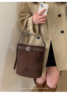 Sac seau sophistiqué en daim marron foncé avec manteau camel et bottes marron hautes