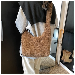Detailed back view of a plush brown faux fur shoulder bag worn by a model