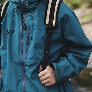 Détail de la veste outdoor bleu canard avec fermetures éclair étanches et capuche fixe