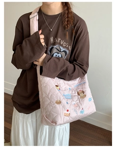 Détail du sac cabas rose matelassé en cœur avec broderies de dessins animés mignons