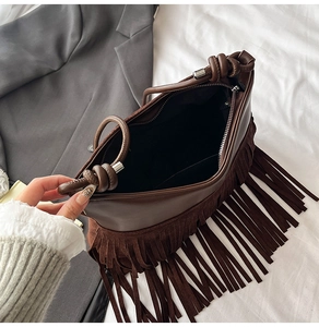Dettaglio della borsa retrò marrone scuro con nappe e chiusura lampo in primo piano