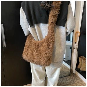 Brown faux fur plush bucket bag worn by model showing large capacity and soft texture