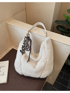 Detail of off-white plush hobo bag with Bonjour charm and leather handle
