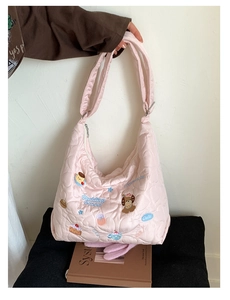 Détail d'un grand sac fourre-tout matelassé rose clair avec broderie de chiot