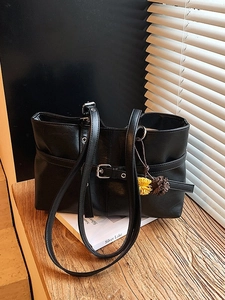 Classic black PU leather tote bag with elegant metal buckles and fuzzy pompom bag charms