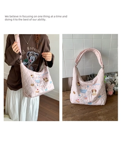Détail du sac hobo rose matelassé avec broderie cartoon Pudding Puppy et motifs de cœur