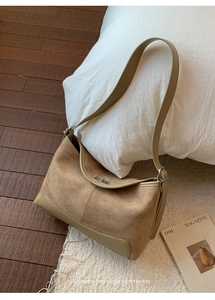 Detail of matte khaki suede texture and metal twist lock on a minimalist shoulder bag